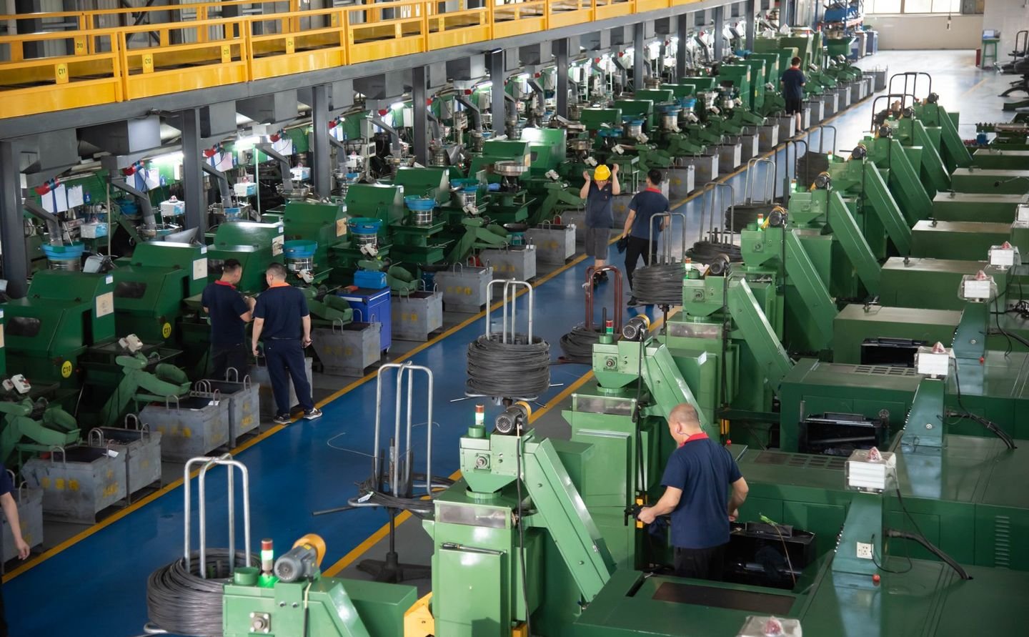 Rows of coiled wire and bar stock on racks in the TYF material area