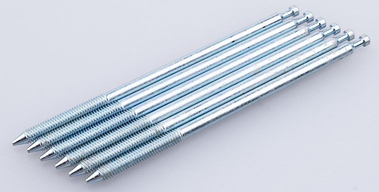 A row of partially threaded pin rods with small heads and pointed threaded ends