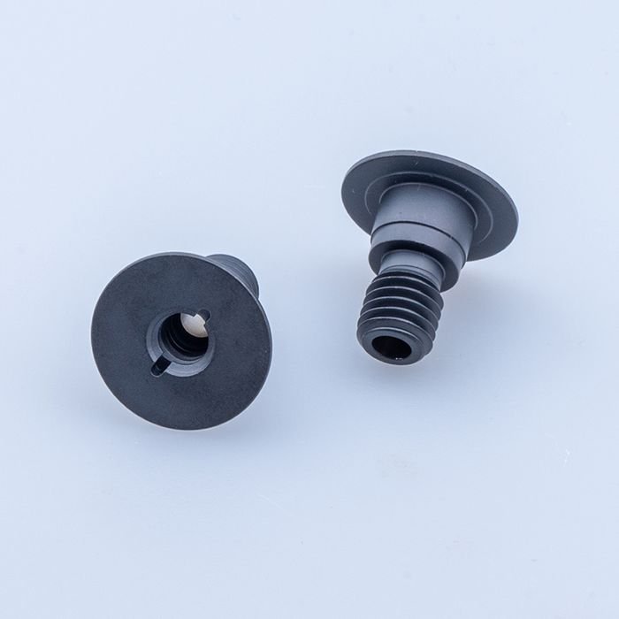 Two black screws with a flat top face and a flange under the head