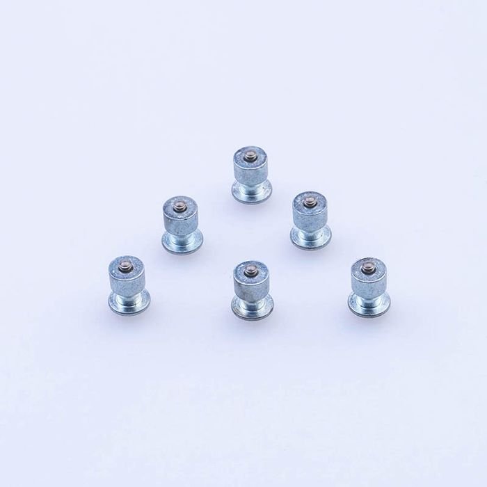 Six zinc-plated tire studs on a white background